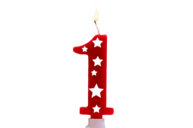 Vela de celebración de cumpleaños número 1 contra un fondo blanco brillante vela de fiesta encendida para el concepto de feliz cumpleaños de un año de edad