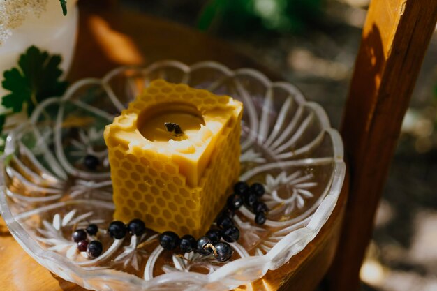 vela de cera con flores rústicas sobre mesa de madera