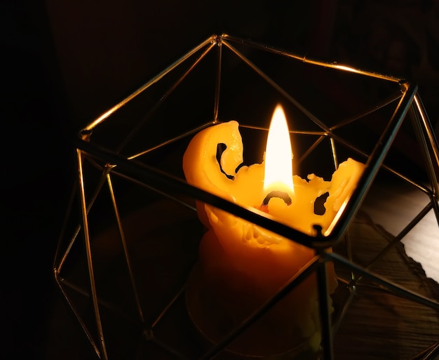 Vela de cera de fusión ardiente en candelabro de metal de estilo moderno