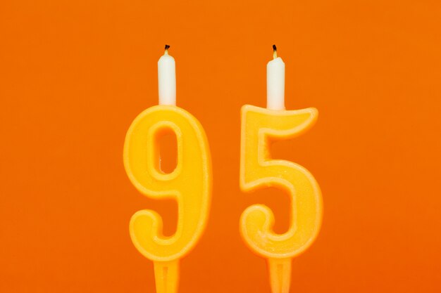 Foto vela de aniversário de cera colorida em fundo laranja