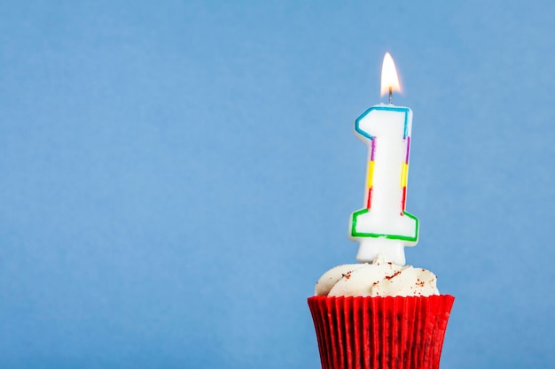 Foto vela de aniversário número 1 em um cupcake contra um fundo azul