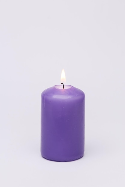 Vela de cera flamejante em fundo branco