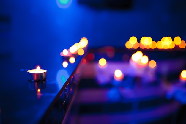 Foto vela de chá e luzes de velas desfocadas no fundo azul