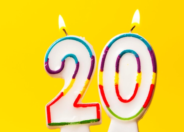 Vela de comemoração de aniversário número 20 contra um fundo amarelo brilhante