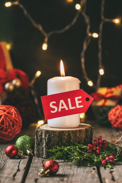 Vela con decoraciones navideñas y cartel de venta en ella