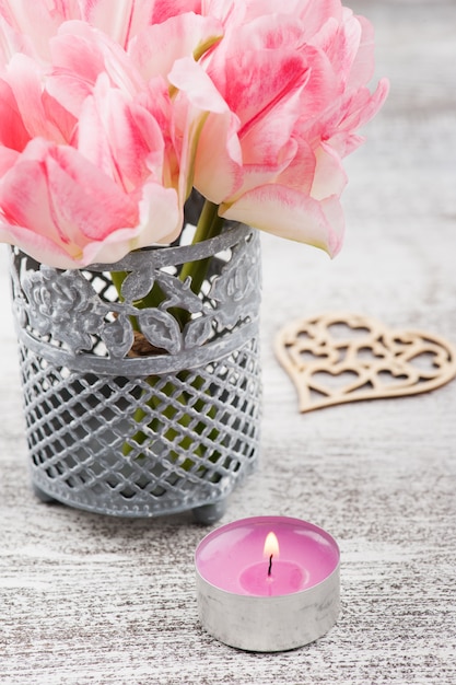 Vela e flores frescas de tulipa rosa