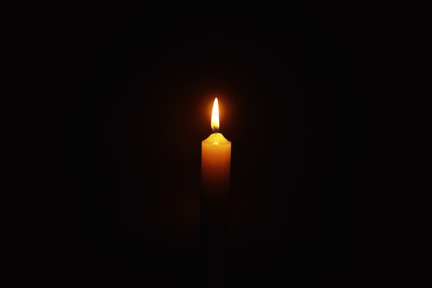 Vela encendida Mecha de una vela en una llama de fuego. Símbolo de tristeza y soledad. Un momento de condolencias. Vela encendida de cera. Religión.