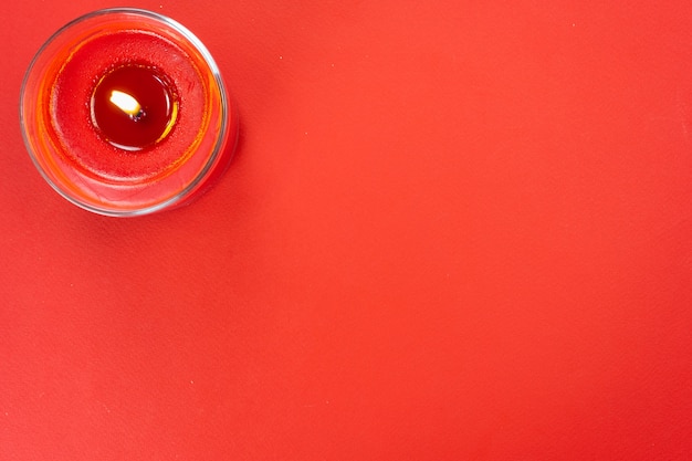 Vela encendida roja sobre un fondo rojo de Navidad. Decoración de año nuevo.