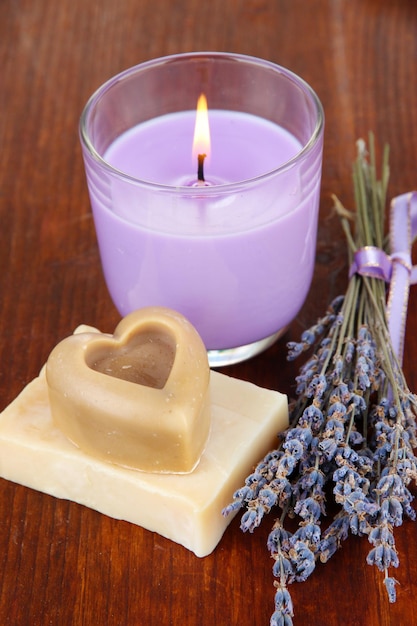 Vela de lavanda con jabón de lavanda fresca sobre fondo de madera