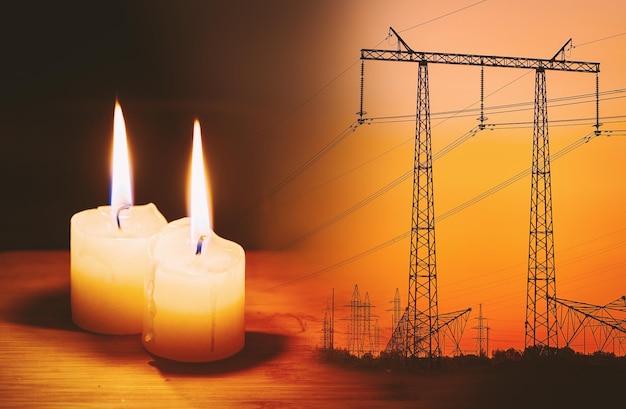 Vela de llama ardiente y líneas eléctricas en el fondo Corte de energía y apagón Crisis energética Aumento del precio de la electricidad para el hogar y la industria