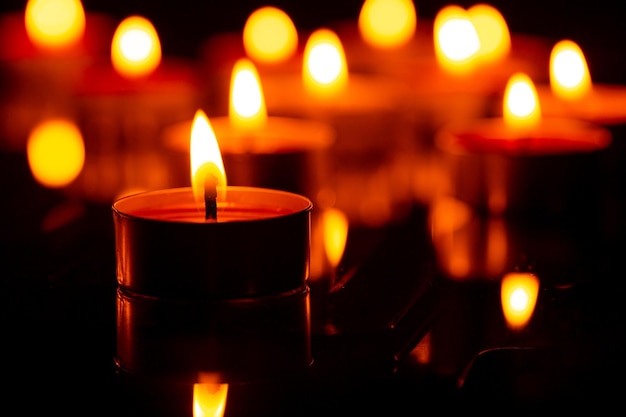 Vela macro, velas acesas à noite. velas brancas acesas no escuro