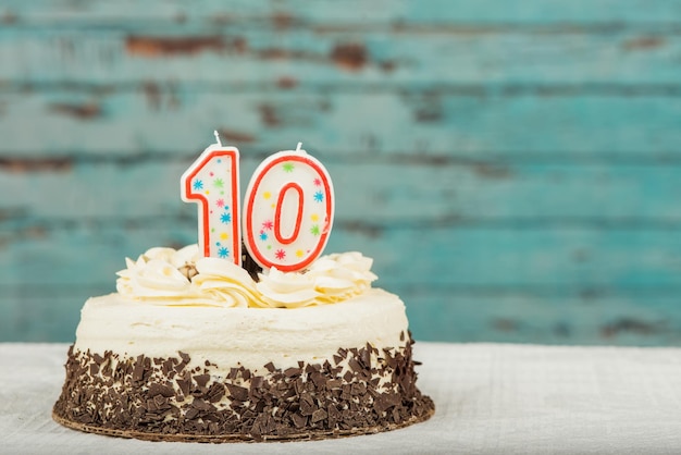La vela número 10 en el pastel de cumpleaños sobre la mesa contra la pared