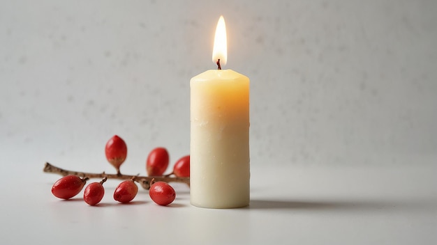 una vela que está encendida con bayas rojas en una mesa