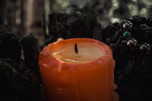 Vela roja apagada con cera un símbolo de la luna un amuleto sobre musgo sobre un fondo natural oscuro tradiciones eslavas Wiccan paganas Brujería un ritual espiritual esotérico