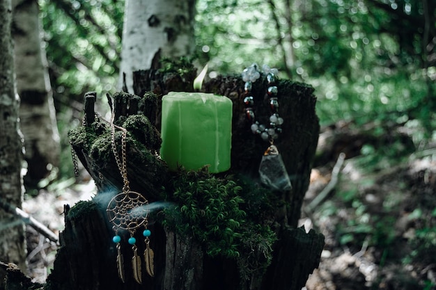 Vela verde acesa um símbolo da lua um amuleto deitado no musgo em um fundo natural escuro pagã tradições eslavas Wicca Bruxaria um ritual espiritual esotérico