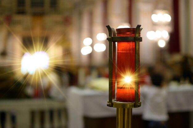 Foto vela votiva encendida dentro de una iglesia que representa la luz divina