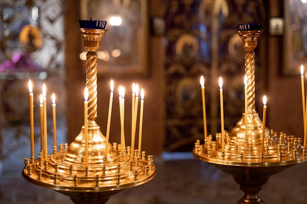 Velas amarillas encendidas en una iglesia ortodoxa con un hermoso interior