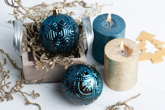 Velas de aroma azul y dorado y juguetes de Navidad en madera rústica