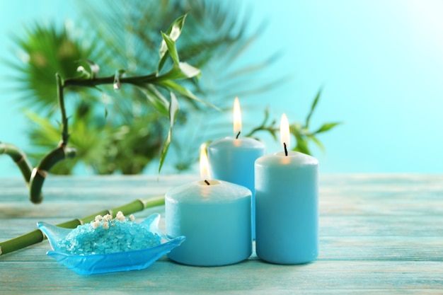 Velas azules con sal de spa y bambú en mesa