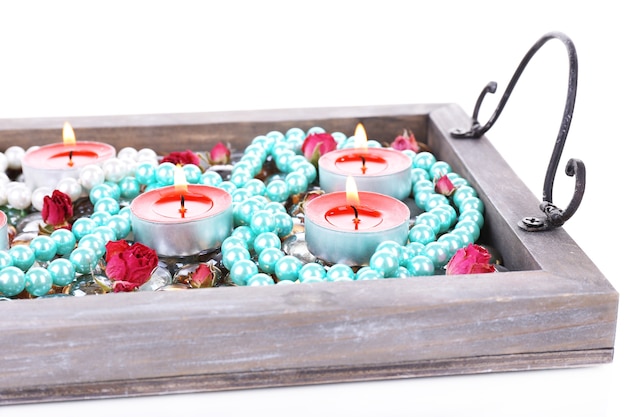 Velas en bandeja vintage con perlas decorativas, piedras, aisladas sobre superficie blanca