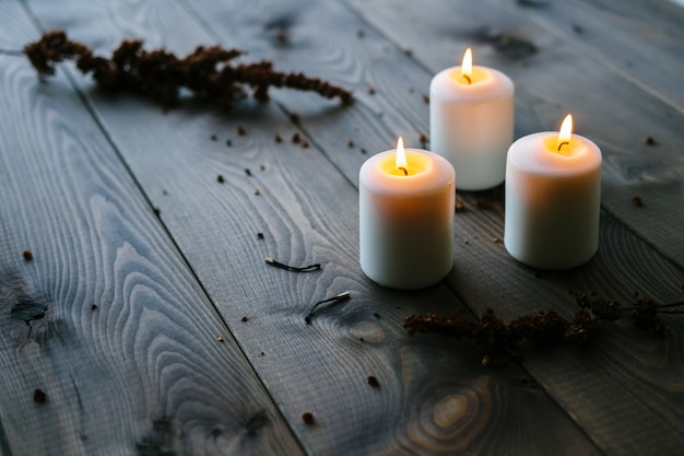 Velas brancas queimando na mesa de madeira