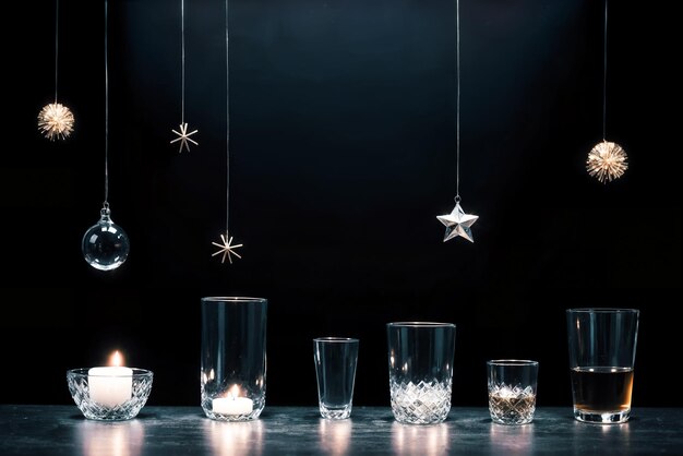 Velas brilhantes em copos em uma superfície negra refletora decoração de Natal