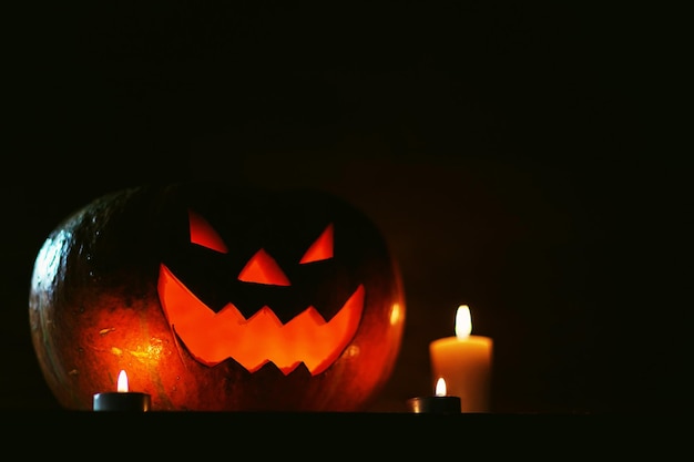 Velas y calabaza para Halloween sobre fondo oscuro