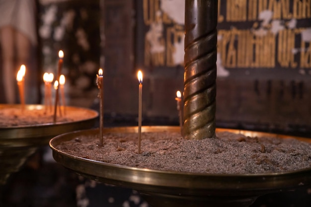 Velas de cera encendidas contra el fondo de una cruz el concepto de oraciones religiosas cristianas para el