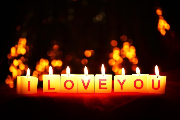 Velas com a placa impressa I LOVE YOU, em desfoque de fundo de luzes