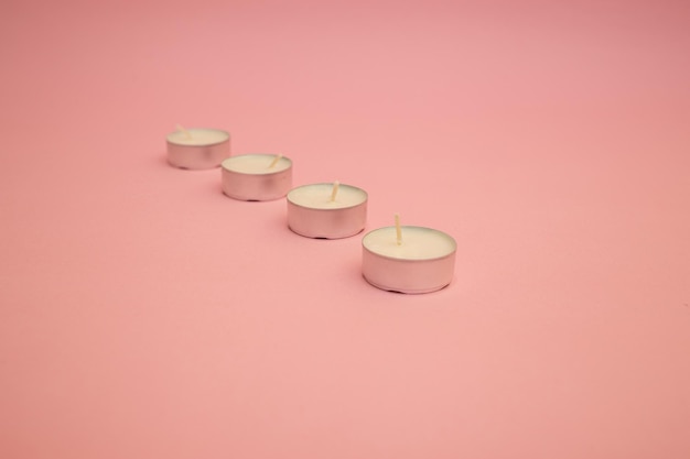 Velas com cera branca em um fundo rosa