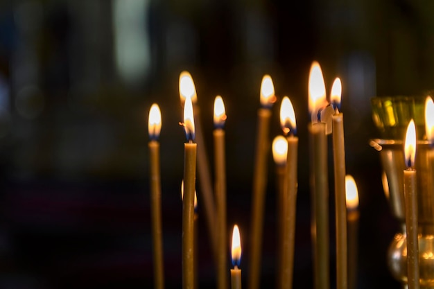 Velas da igreja no fundo dos ícones na catedral ortodoxa russa