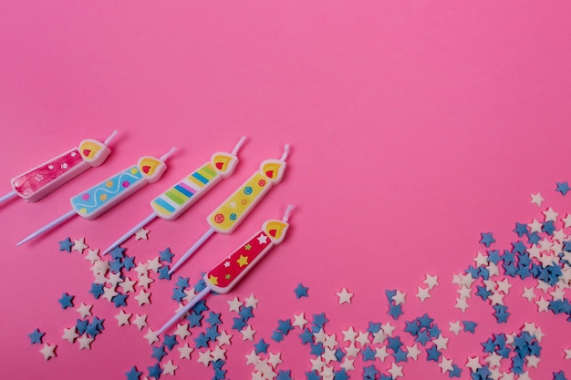 Velas de aniversário e confetes em uma vista superior de fundo rosa Modelo de layout de estilo simples