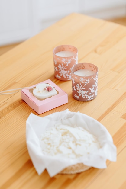 Velas de mesa de madeira natural em castiçal com ornamento floral sachê florentino em caixa rosa