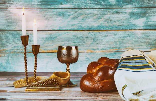 Foto velas de mesa de véspera do shabat e copo de vinho com pão chalá coberto,