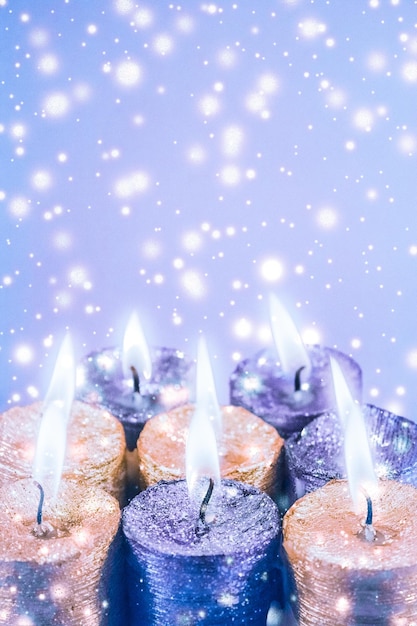 Foto velas de natal e neve brilhante na decoração da temporada de férias de fundo azul