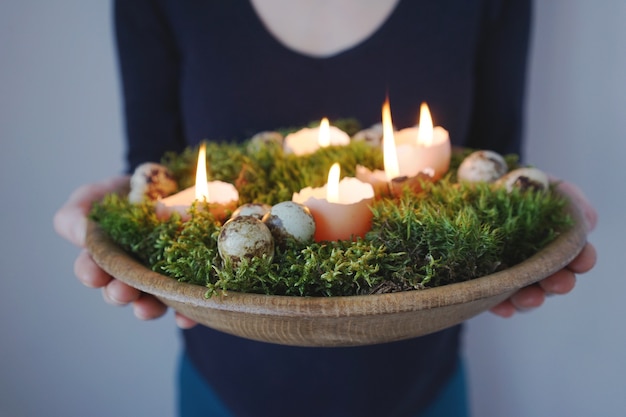 Velas decorativas de Pascua de cáscaras de huevo en un jarrón de madera