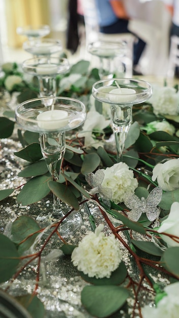 Velas em um copo em um casamento com flores na mesa 2