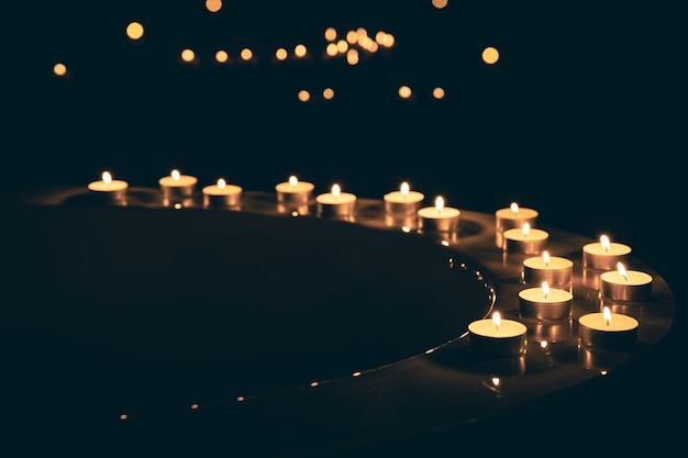 Velas encendidas en el baño en la oscuridad.