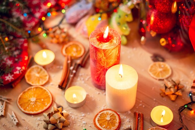 Velas encendidas blancas y rojas sobre la mesa. Decoraciones navideñas brillantes