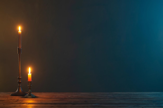 Velas encendidas en candelabros vintage sobre fondo oscuro