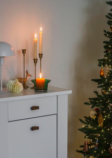 Velas encendidas en una cómoda blanca Acogedora noche de Navidad en la sala de estar