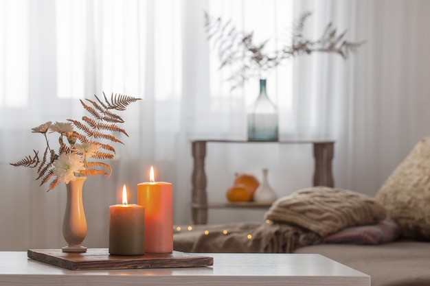 Foto velas encendidas con decoración otoñal en mesa blanca en casa