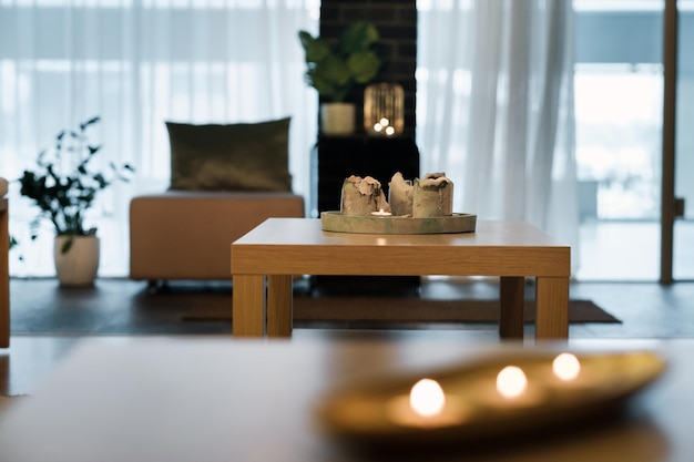 Las velas encendidas están sobre la mesa en la habitación. Iluminación interior atmosférica.