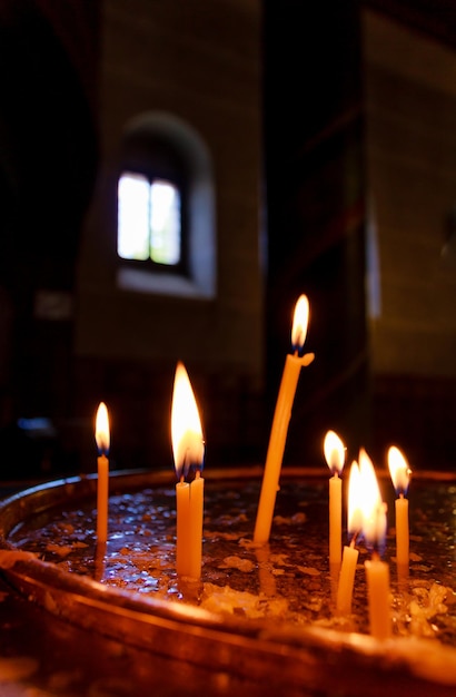 Velas encendidas en una iglesia, llamas de velas