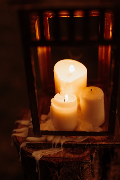 Velas encendidas en una noche oscura en una linterna de madera como decoración para unas vacaciones