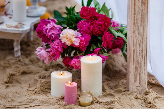 Velas y flores frescas en la playa.