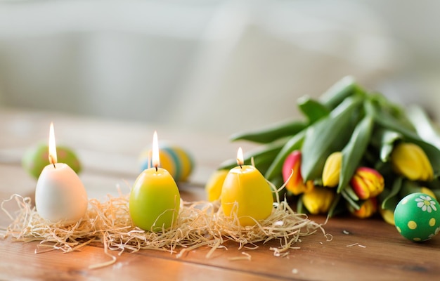 velas en forma de huevos de Pascua y flores de tulipán
