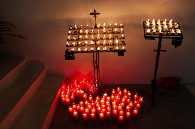 Velas en una iglesia con una cruz en el medio