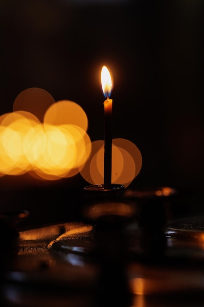 Las velas de la iglesia en la fe y la religión del templo para cristianos y católicos se iluminan en la oscuridad