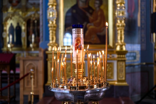 Velas de la iglesia en el fondo de iconos en la catedral ortodoxa rusa